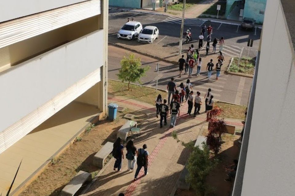 Foto tirada do alto de um prédio, de alunos que passeiam pelo Câmpus 