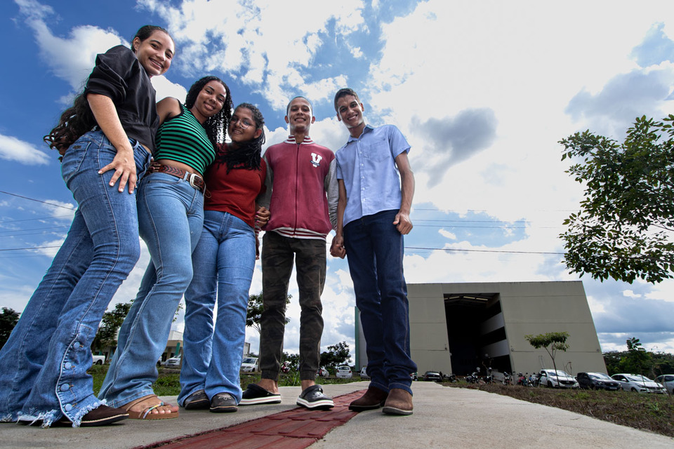 Grupo de estudantes em pé e abraçados