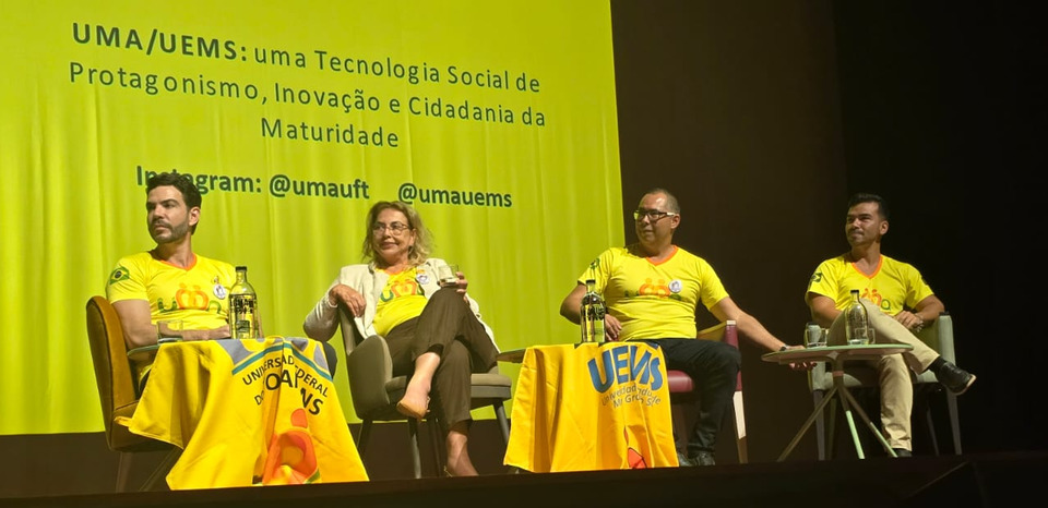 Academicos da uma sentados em um palco 