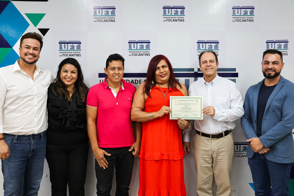 professora segura diploma retificado ao lado do reitor e de outros servidores da UFT