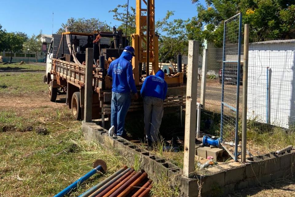 Foto com homems trabalhando ao lado de um caminhão em local onde fica a bomba d'água do Câmpus de Palmas