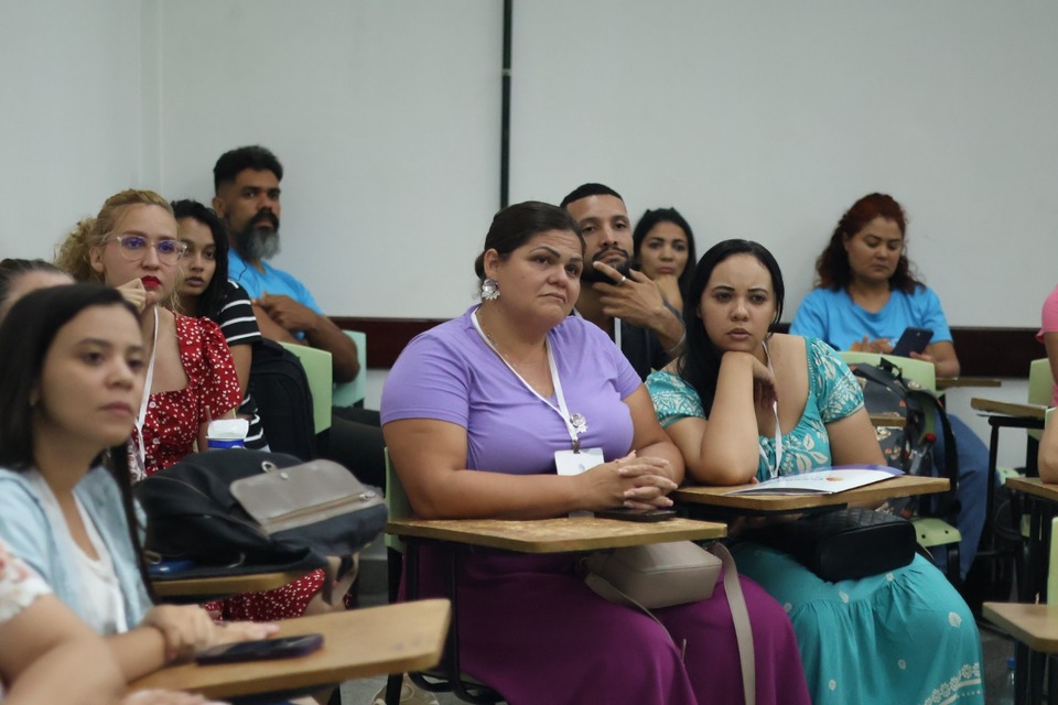 pessoas sentadas em cadeiras dentro de uma sala de aula
