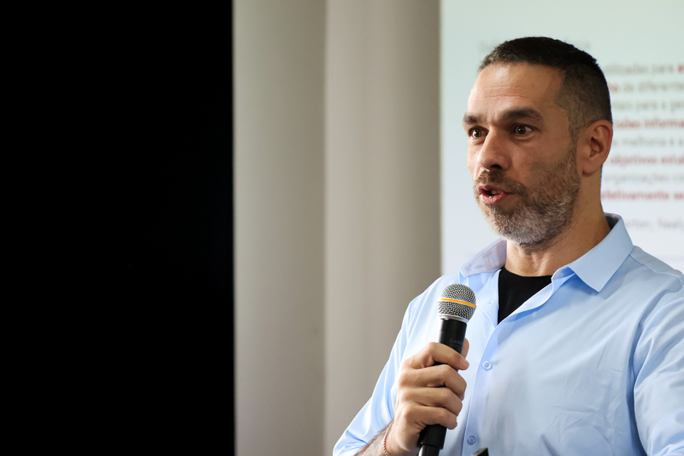 Homem branco falando ao microfone