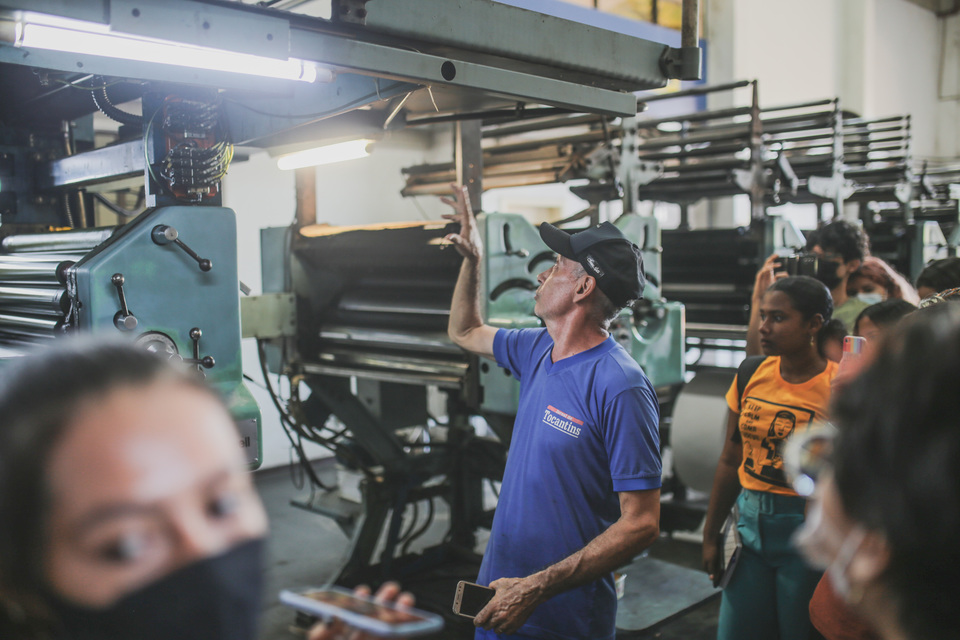 João Maciel explicando como manusear máquina de impressão de jornais impressos