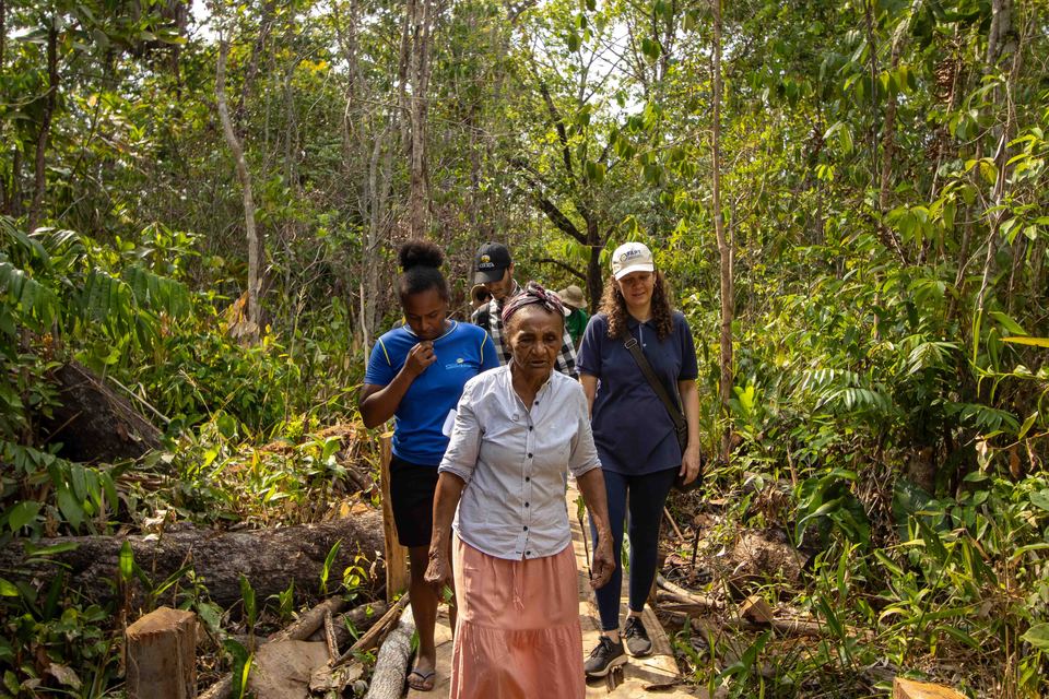 pessoas negras andando em meio a mata fechada