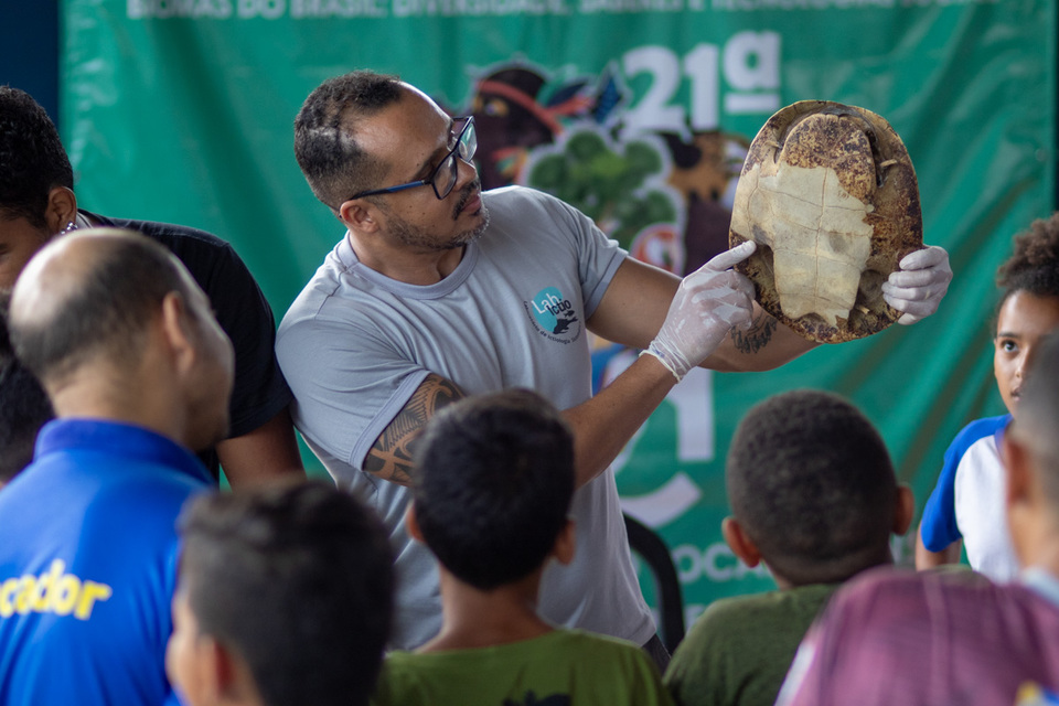 professor mostra o casco de uma tartaruga para estudantes