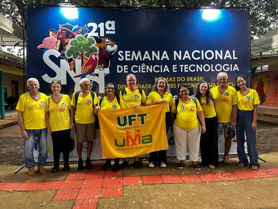 diversos idosos de camisa amarela seguram bandeira com dizeres referentes à UFT e UMA
