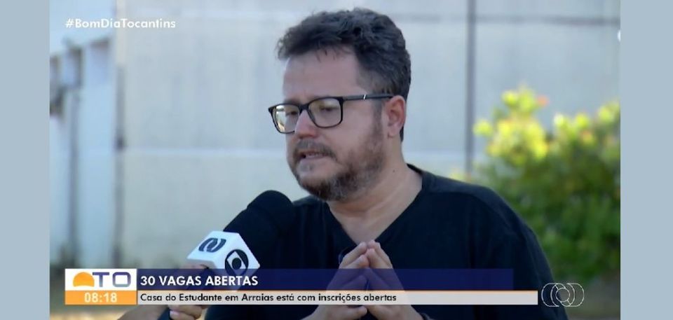 Homem branco com blusa azul em entrevista para a TV