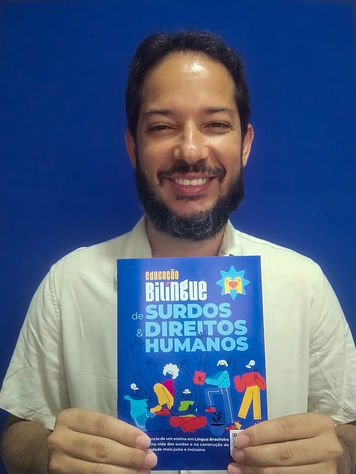 homem segura cartilha nas mãos