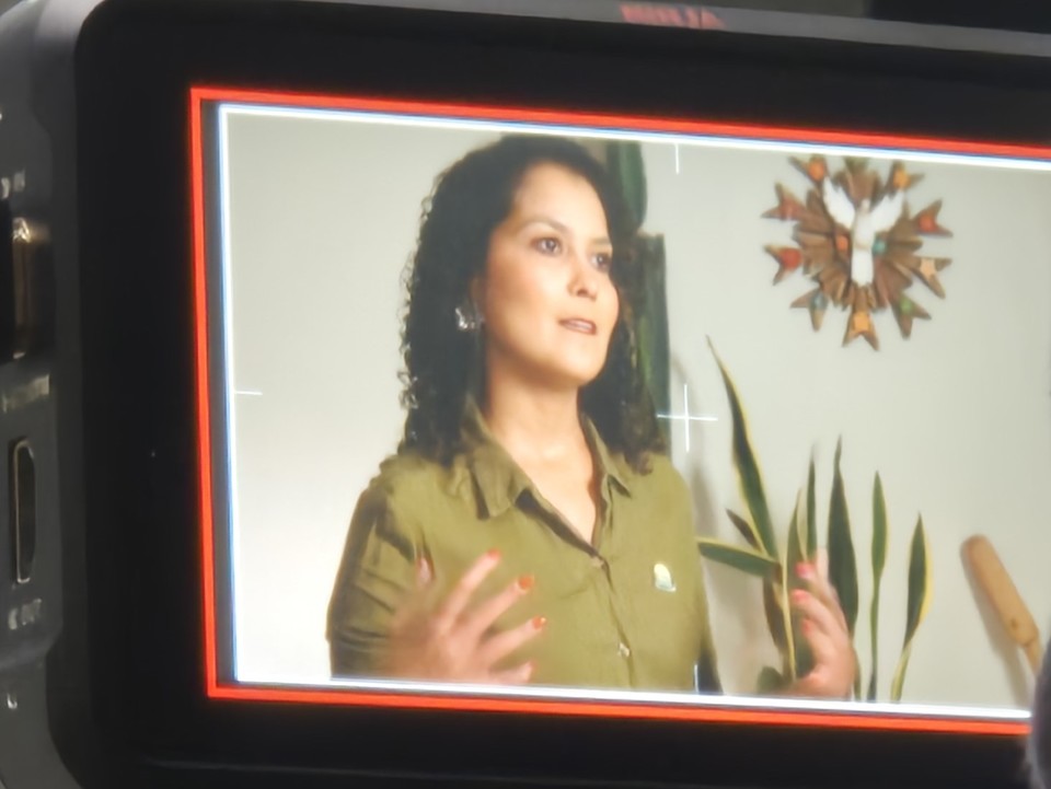 Imagem da professora aparece na tela de uma câmera