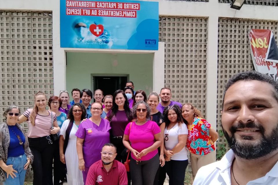 Foto de profissionais, sorrindo para a câmera, em frente ao prédio do Cepic-UFT