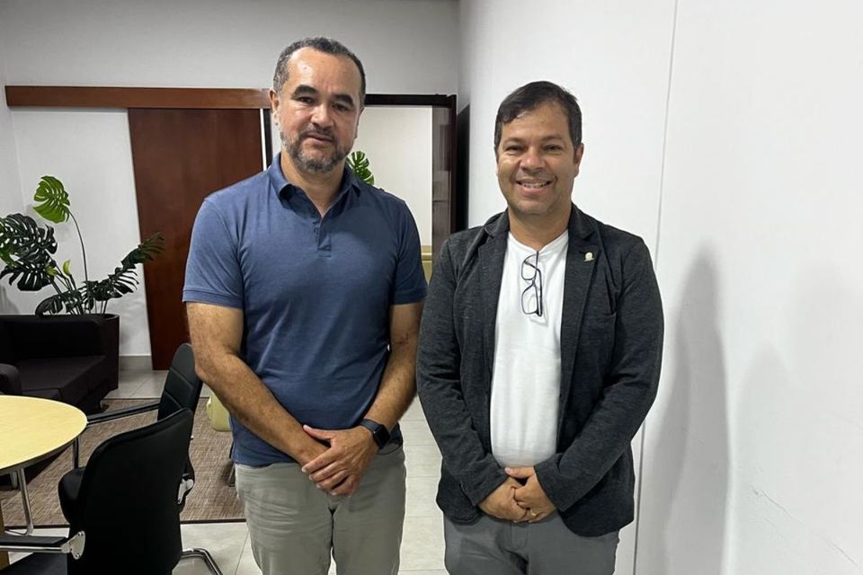 A foto mostra o diretor Moisés Neto e o secretário Paulo Cézar Silva, em pé, olhando para a camêra, demonstrando um clima de colaboração